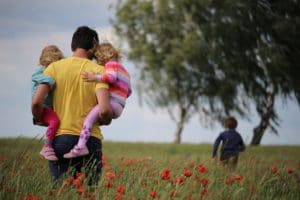 father carrying his children through a field - Dan Moisand discusses the estate planning documents most everyone needs